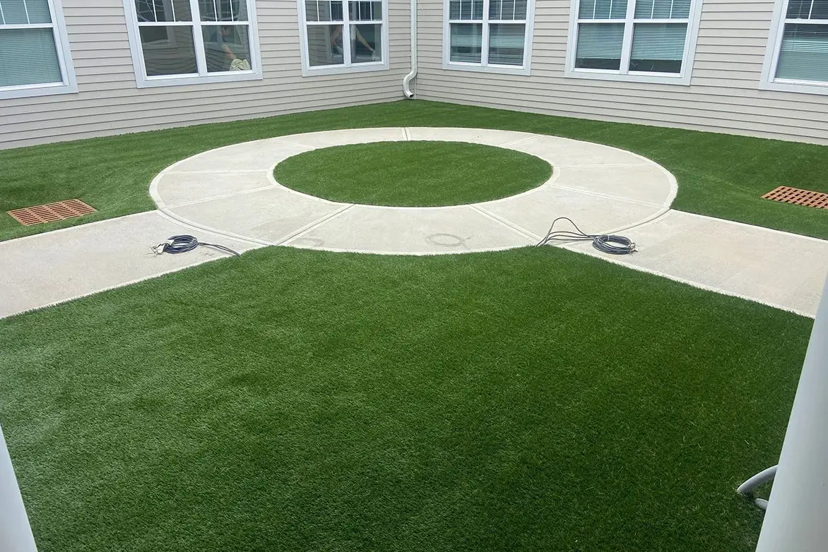 A patio area with grass and concrete.