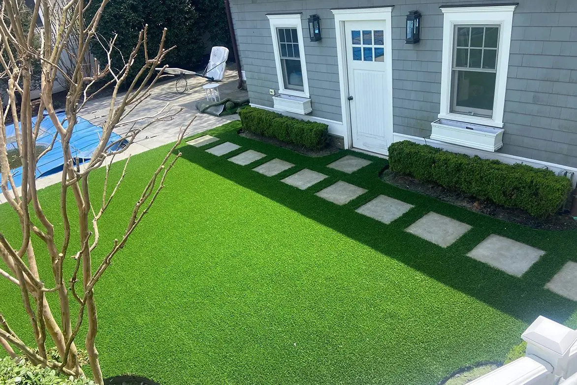 A backyard with a lawn and a house