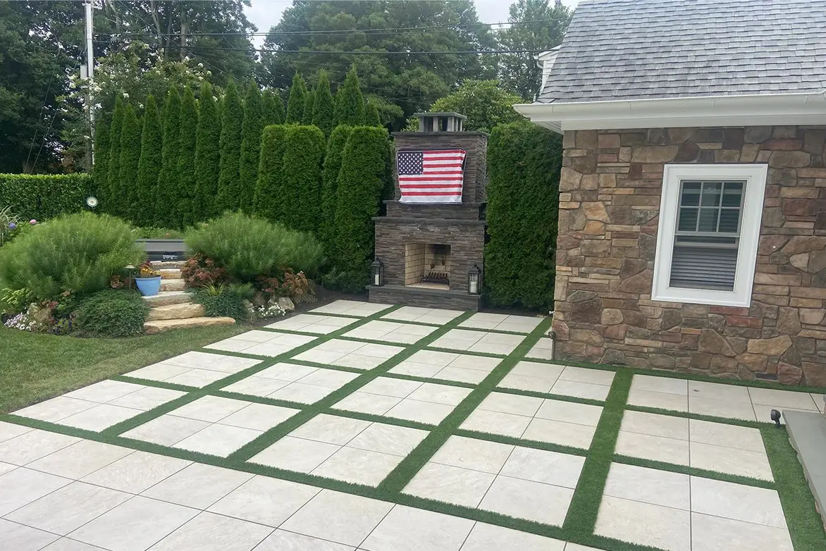 A patio with grass and brick in the middle of it